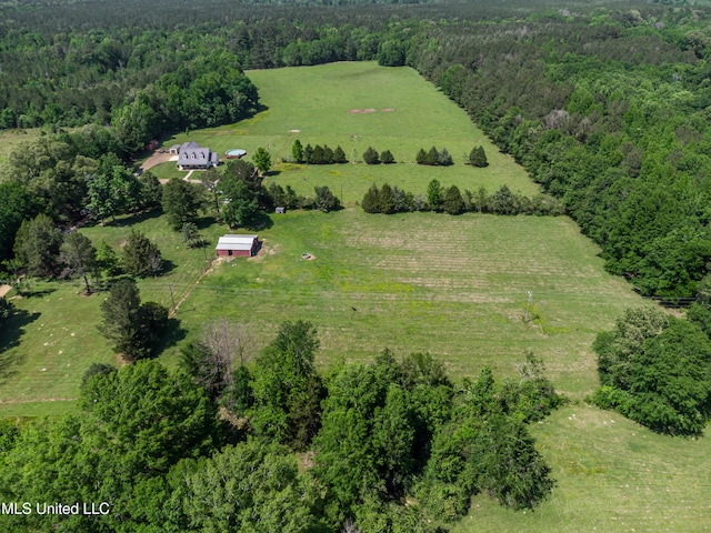 drone / aerial view featuring a view of trees and a rural view
