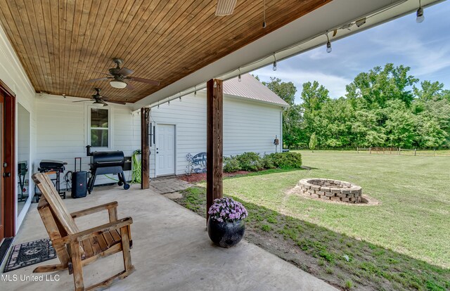 view of patio / terrace featuring area for grilling, a ceiling fan, and an outdoor fire pit