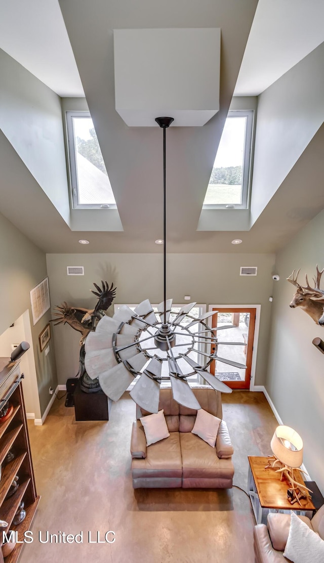 living area featuring a skylight, a high ceiling, and visible vents