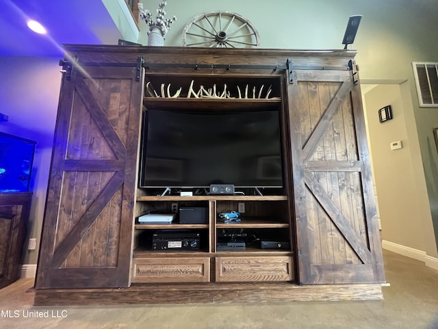 interior details with baseboards, visible vents, and a barn door