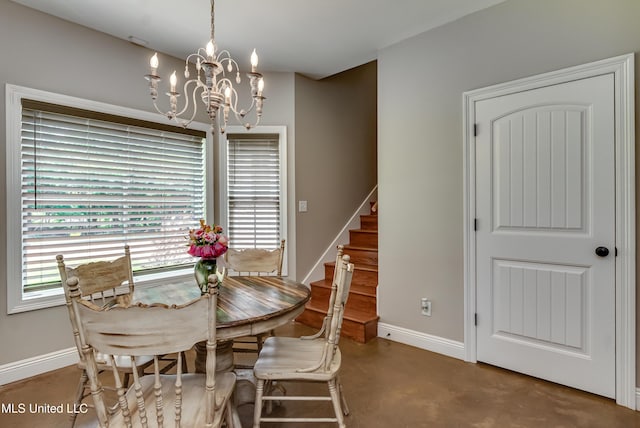 dining space featuring baseboards, concrete floors, a chandelier, and stairway