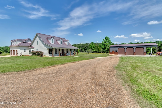 view of front of home featuring covered porch, driveway, an outdoor structure, and a front lawn