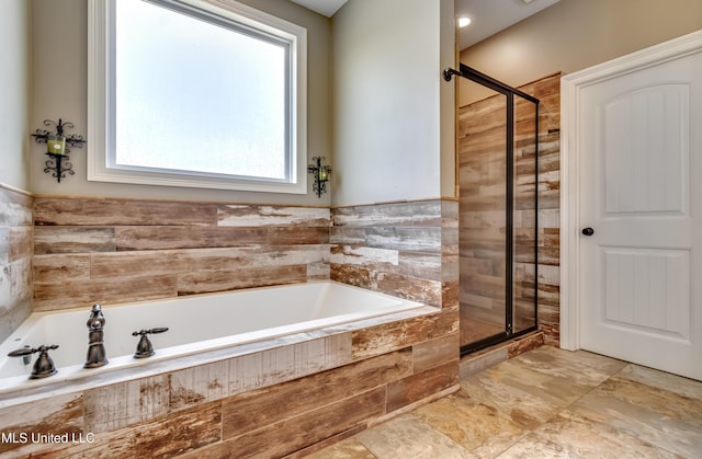 bathroom with a stall shower and a bath