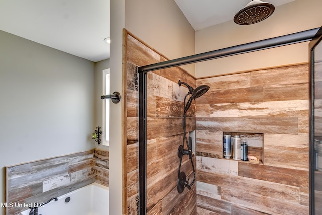 bathroom featuring a garden tub and a shower stall