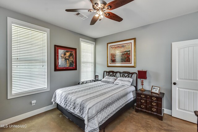 carpeted bedroom featuring baseboards, a ceiling fan, and visible vents