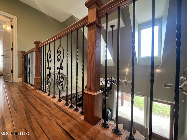 staircase featuring a high ceiling, wood finished floors, and visible vents