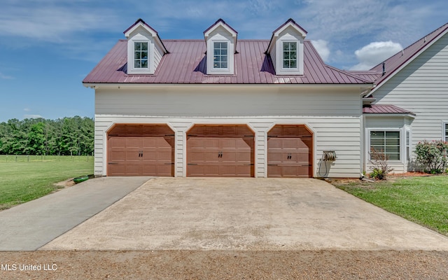 cape cod home with driveway, metal roof, and a front yard