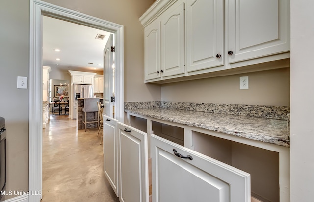 interior space featuring visible vents, finished concrete flooring, recessed lighting, white cabinets, and light stone counters