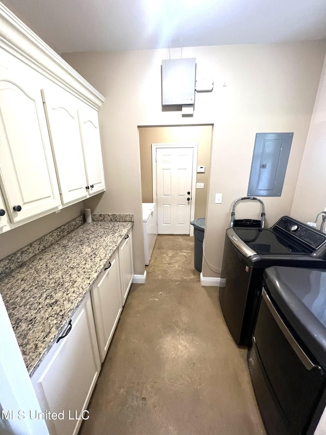laundry area with baseboards, electric panel, cabinet space, and washer and clothes dryer