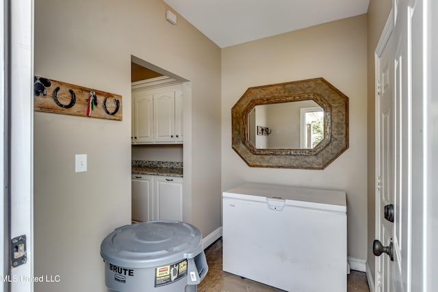 laundry area with baseboards