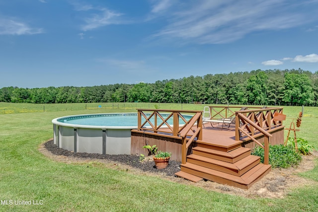pool featuring a lawn, a wooden deck, and a wooded view