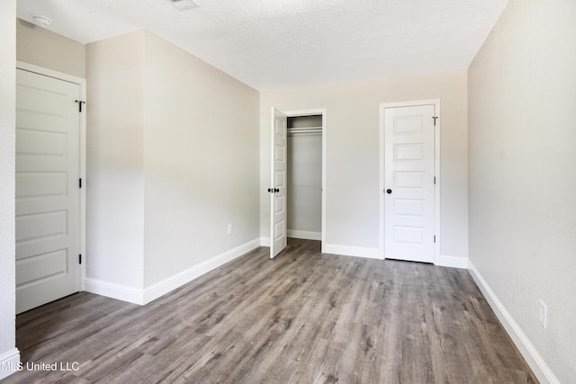 unfurnished bedroom with light hardwood / wood-style floors, a closet, and a textured ceiling