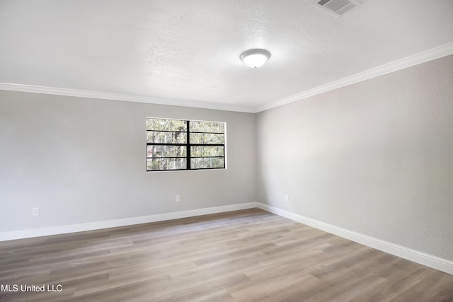 spare room with hardwood / wood-style floors, ornamental molding, and a textured ceiling