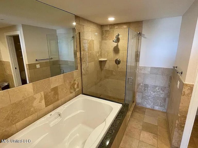 2060 Beach Blvd Unit 1206, Biloxi, MS 39531 - full bathroom featuring tile walls, a stall shower, a bath, and wainscoting