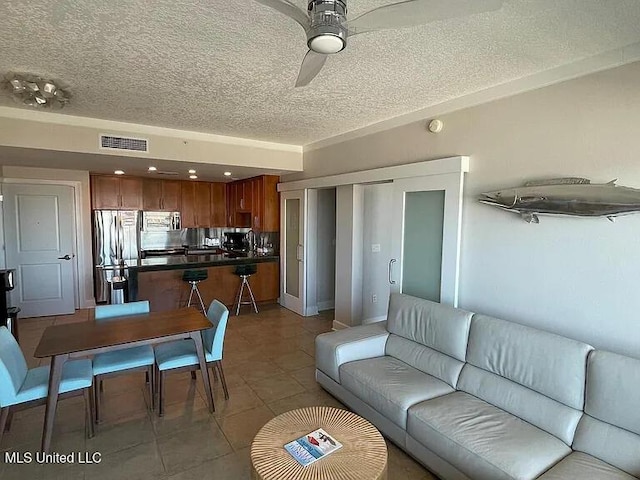2060 Beach Blvd Unit 1206, Biloxi, MS 39531 - living room featuring a textured ceiling, ceiling fan, and tile patterned flooring