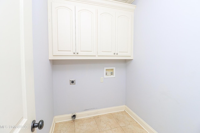 clothes washing area with electric dryer hookup, hookup for a washing machine, baseboards, and cabinet space