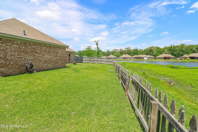 view of yard featuring a water view and fence