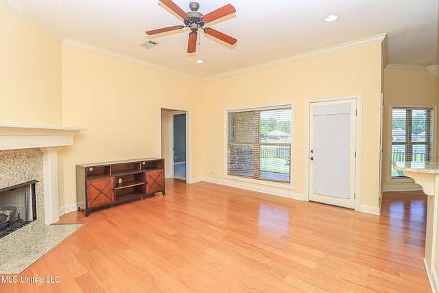 unfurnished living room featuring crown molding, ceiling fan, a wealth of natural light, and light wood-type flooring