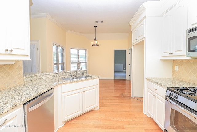 kitchen with a peninsula, light wood-type flooring, a sink, appliances with stainless steel finishes, and a notable chandelier