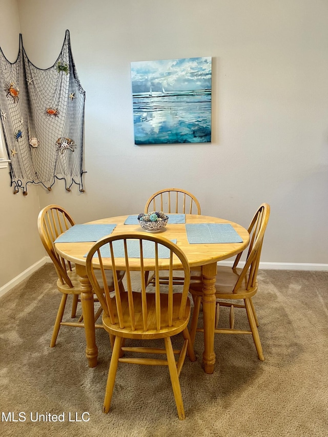 dining space with baseboards and carpet