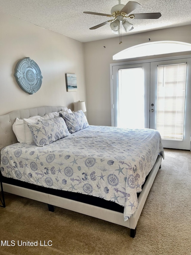 carpeted bedroom featuring a ceiling fan, french doors, and a textured ceiling