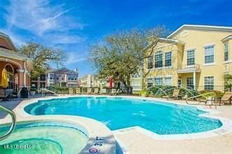 pool with a patio and a hot tub