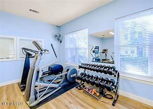 workout area with baseboards, wood finished floors, and visible vents