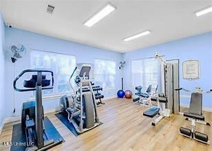 gym with baseboards and wood finished floors