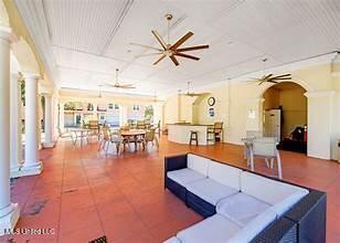 living area featuring a ceiling fan and decorative columns