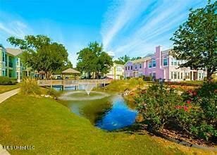 view of home's community featuring a lawn and a water view