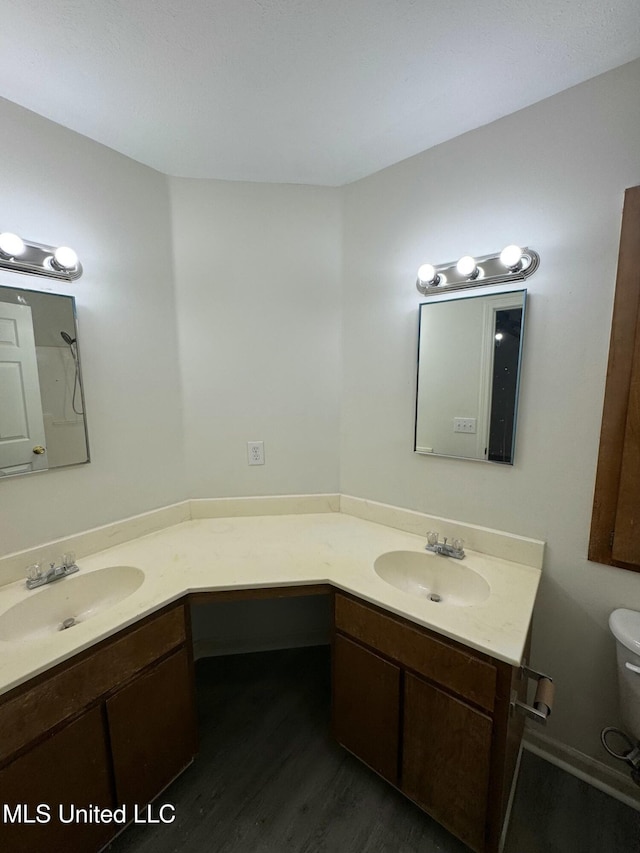 bathroom with hardwood / wood-style flooring, vanity, and toilet