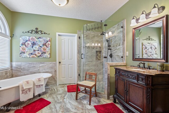 9476 Plantation Rd, Olive Branch, MS 38654 - bathroom featuring vanity, a stall shower, a freestanding bath, a textured ceiling, and marble finish floor