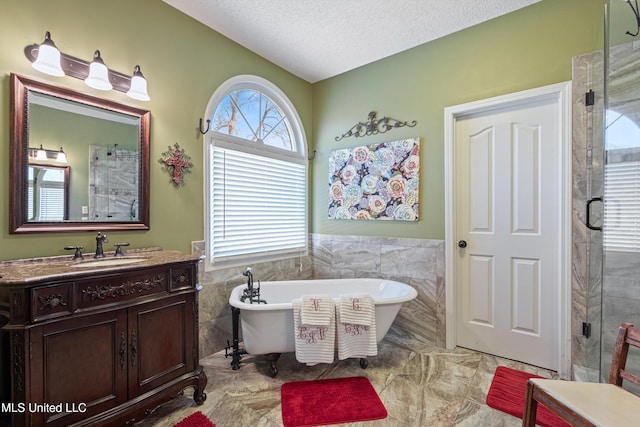 9476 Plantation Rd, Olive Branch, MS 38654 - bathroom with vanity, a soaking tub, tile walls, and a textured ceiling