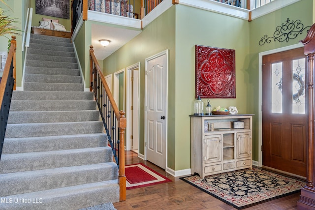 9476 Plantation Rd, Olive Branch, MS 38654 - foyer entrance featuring stairway, baseboards, wood finished floors, and a towering ceiling
