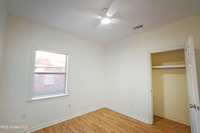 unfurnished bedroom featuring a closet, light hardwood / wood-style floors, and ceiling fan