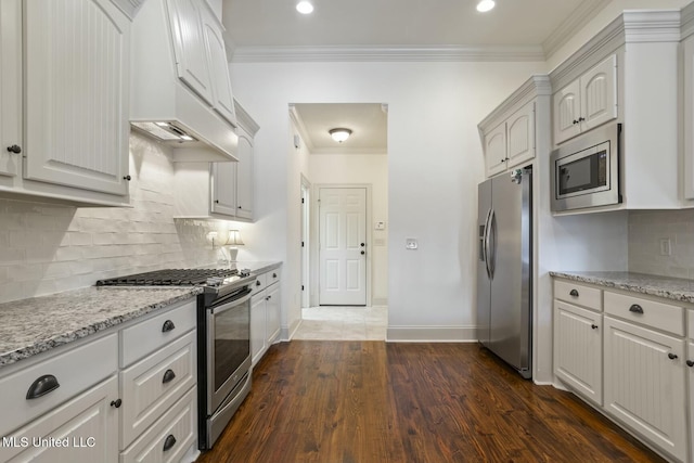 kitchen featuring dark wood-type flooring, appliances with stainless steel finishes, crown molding, baseboards, and light stone countertops