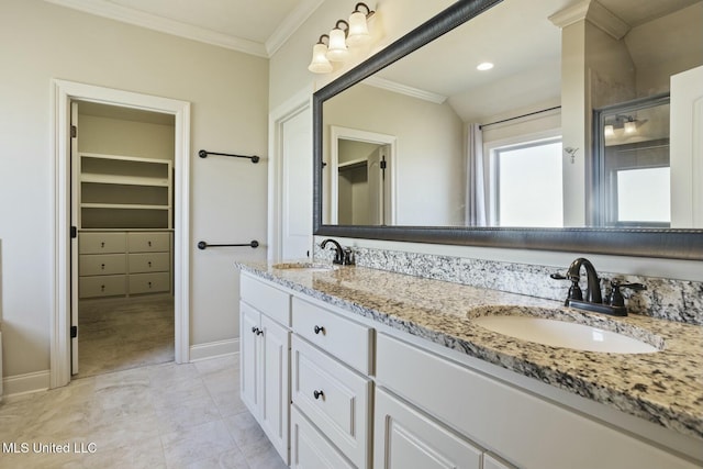 bathroom featuring double vanity, ornamental molding, baseboards, and a sink