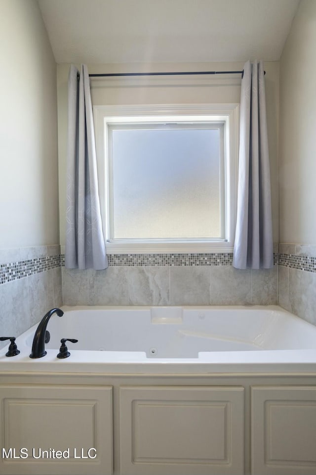 bathroom featuring a healthy amount of sunlight and a jetted tub