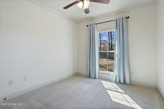 empty room with a ceiling fan, crown molding, baseboards, and carpet floors