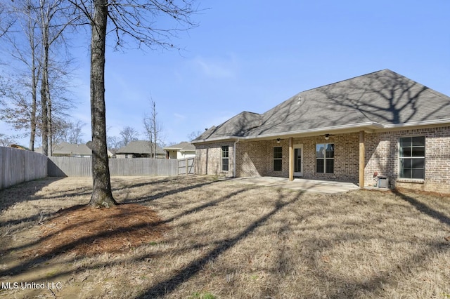 rear view of house with a patio, brick siding, a fenced backyard, and a ceiling fan