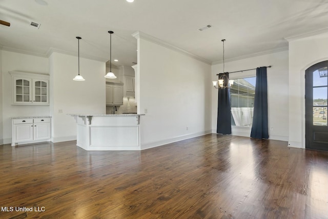 unfurnished living room with dark wood-type flooring, visible vents, arched walkways, and ornamental molding