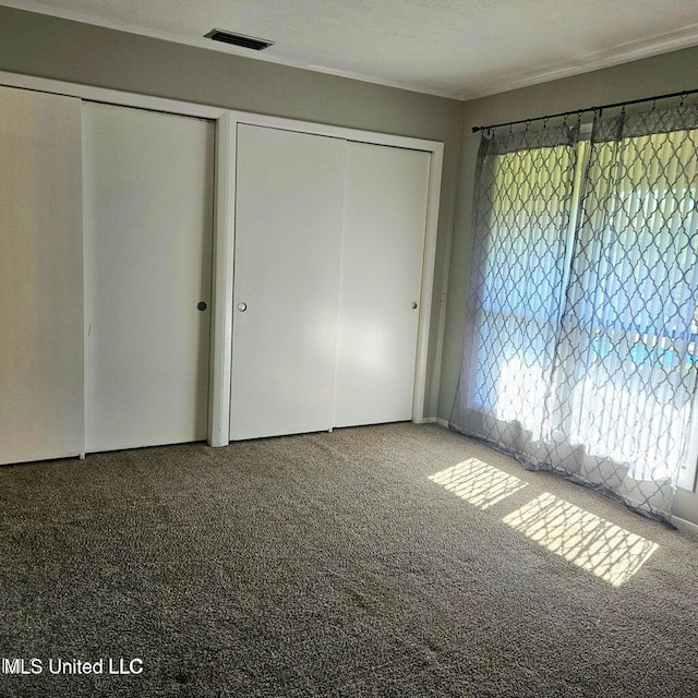 266 Lanai Unit U, Diamondhead, MS 39525 - unfurnished bedroom with two closets, visible vents, and carpet