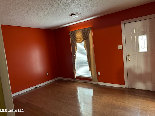 entryway featuring hardwood / wood-style floors and a textured ceiling