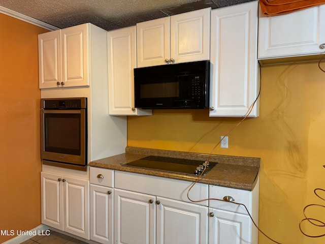 kitchen with ornamental molding, white cabinets, black appliances, and a textured ceiling