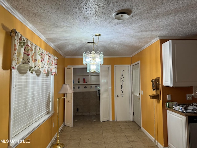 kitchen with crown molding, a textured ceiling, a chandelier, and decorative light fixtures