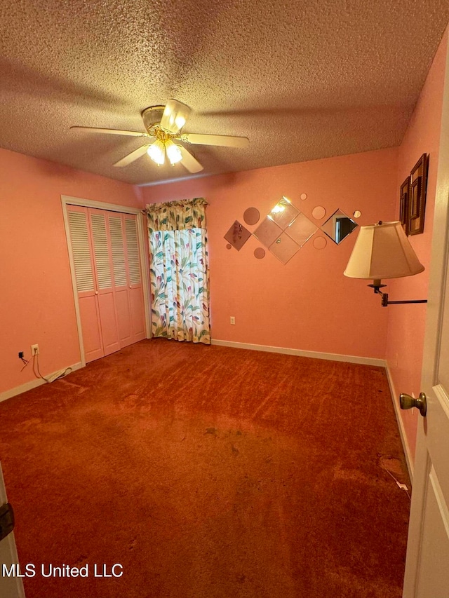 empty room featuring ceiling fan, a textured ceiling, and carpet floors