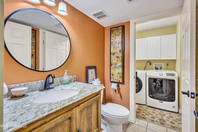 bathroom featuring vanity, tile patterned floors, washer and dryer, and toilet