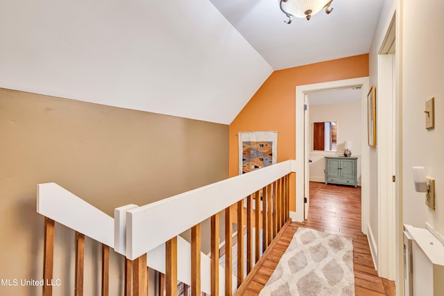 hall with vaulted ceiling and hardwood / wood-style flooring