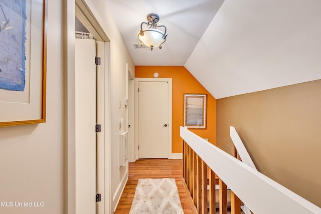 hall with light hardwood / wood-style floors and lofted ceiling