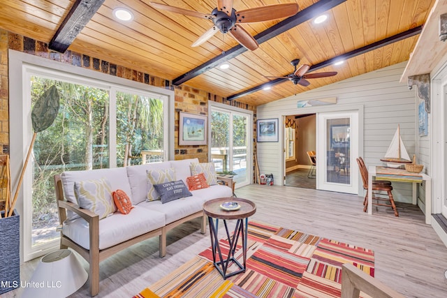 living room featuring wood ceiling, wooden walls, lofted ceiling with beams, light hardwood / wood-style floors, and ceiling fan